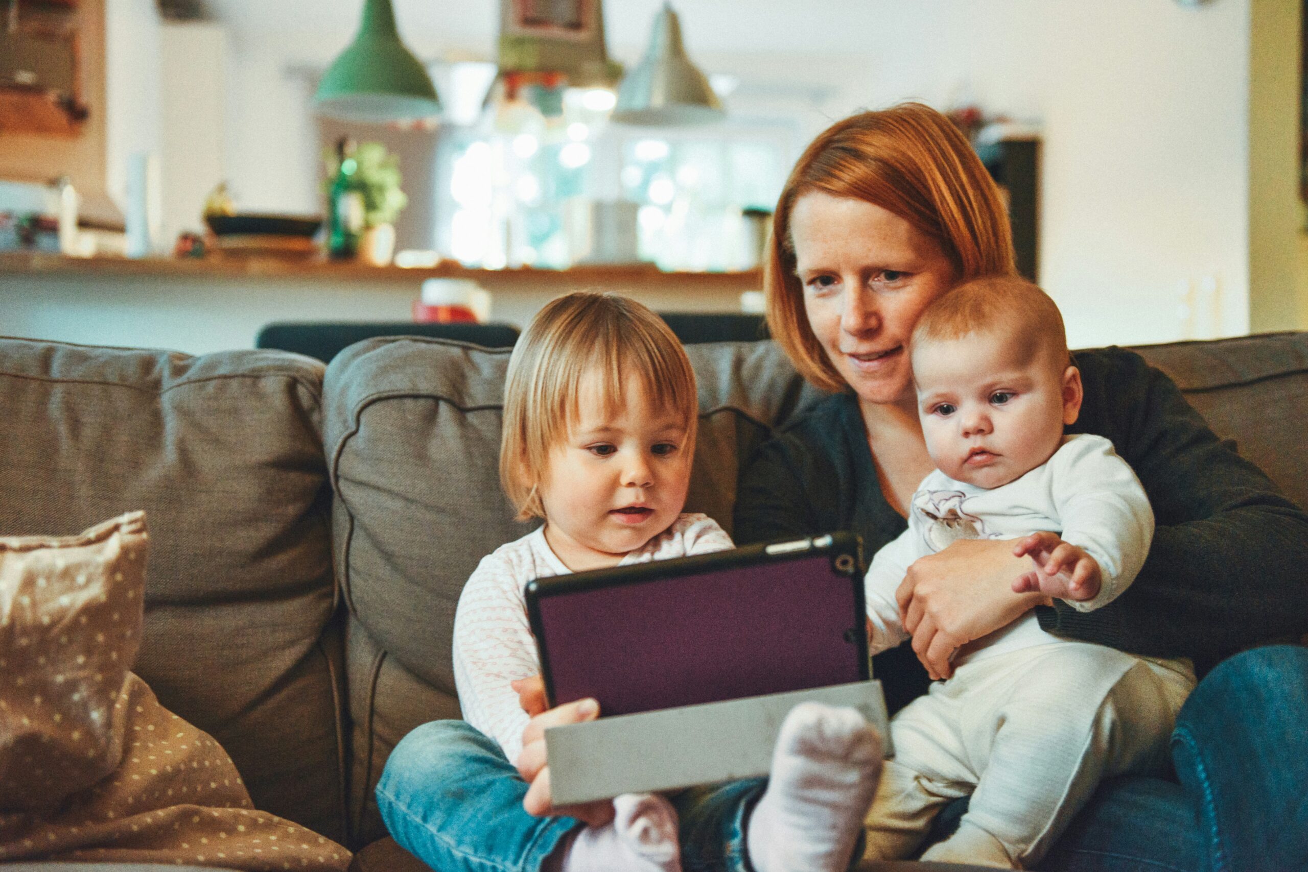 母親とタブレットを見る二人の子ども