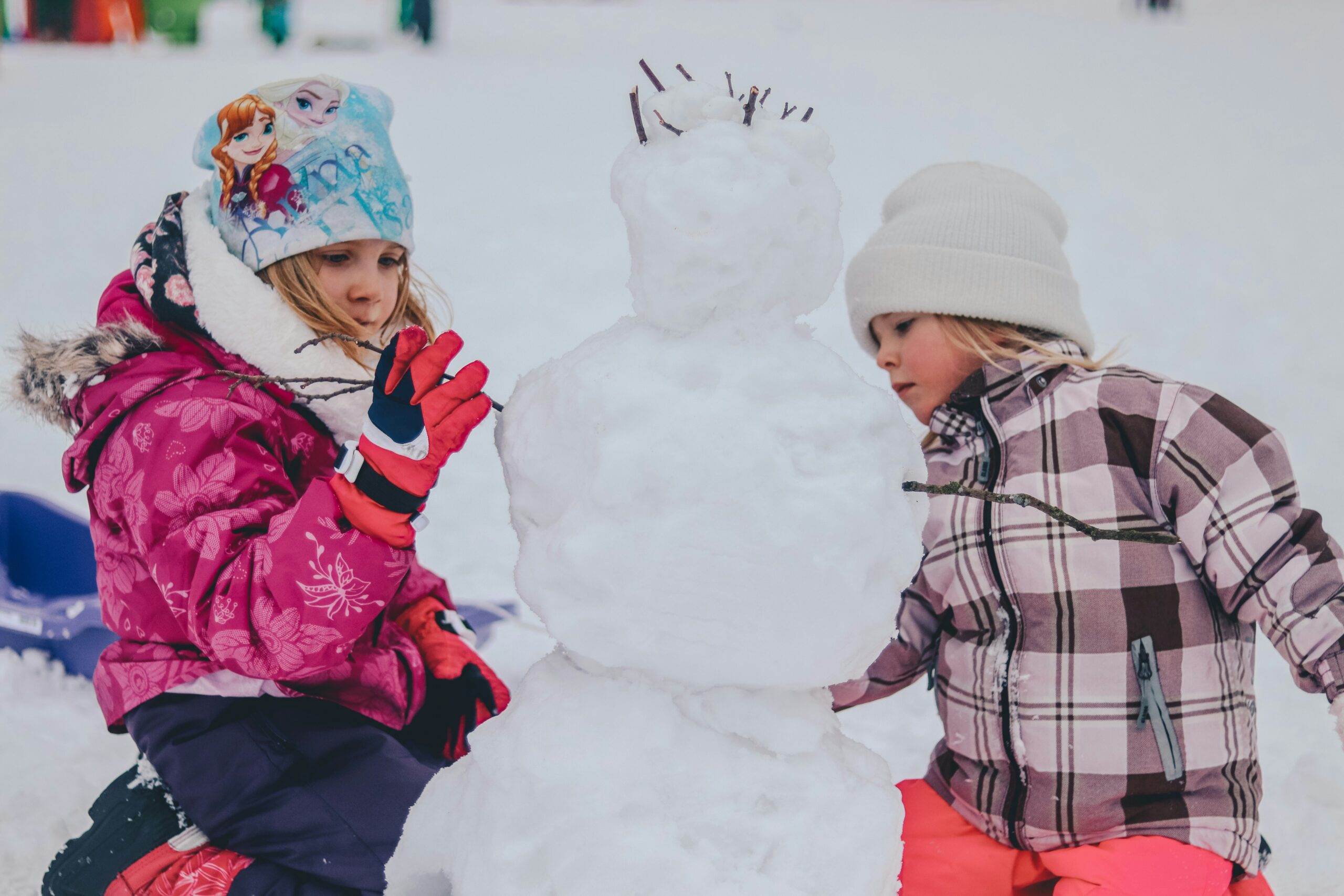 きょうだいで雪だるまを作って遊んでいる